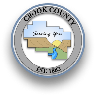 Crook County Oregon logo shows outline of county with sun, cliffs and river running through.